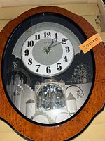Front view of Rhythm Small World wall clock showing dial and animated scene