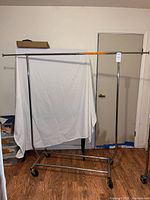 Front view of chrome rolling garment rack showing overall structure and casters