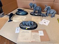 Group shot of all six sculptures, certificates visible