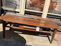 Full view of coffee table front showing drawer and legs