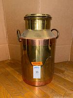 Full view of brass milk can with copper accents and handles