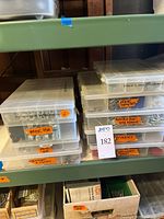 Stacked clear plastic organizer boxes labeled for various hardware