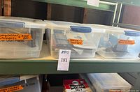 Shelf view showing three clear bins, lot is center bin labelled paint sprayer