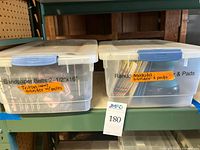 Two lidded plastic bins labelled for Triton sander with belts and Makita sander with pads