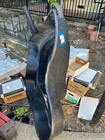 Side view of black molded pond liner standing vertically