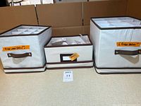 Three fabric storage containers with labels indicating Riedel glasses