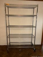 Full view of chrome wire rack with six shelf positions and wheels