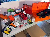 Overall view of both orange toolboxes and assorted emergency supplies laid out on table