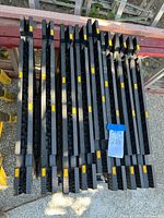 Eight folded sawhorses laid flat showing yellow tabs and ribbed structure