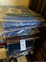 Stack of seven sealed tarps in assorted colors