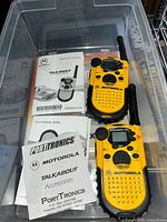 Pair of yellow Motorola Talkabout 200 radios with manuals inside plastic bin