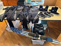 Overview of water ski, wetsuits and boots on table