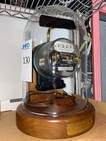 Meter inside glass dome on wood base