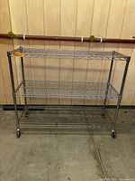 Full view of empty chrome wire rack highlighting three shelves and casters