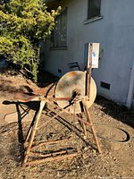 Side view of grindstone showing full frame, seat, stone, treadle and belt