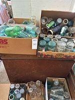Four boxes filled with assorted vintage canning jars, various colors and lids