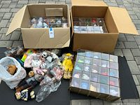 Two open cartons containing multiple acrylic-cased Beanie Babies plus loose bagged plush showing volume of lot