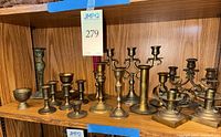 Shelf view showing full assortment of brass candle holders