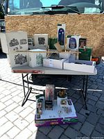 Overall lot showing boxed Department 56 buildings and accessories on table