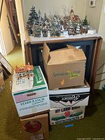 Overall view of village display on TV stand with additional boxed pieces below