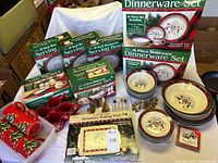 Overall view of boxed dinnerware, loose plates, bowls, mugs and napkin rings