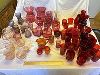 Overall lot showing variety of coloured glass pieces laid out on table