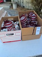 Two boxes filled with ruby red flash diamond point bowls and dishes