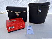 Two binocular cases and slide viewer box on table