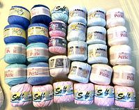 Front view of 30 balls cotton yarn arranged in five columns by six rows showing colour range and labels