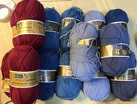 Group of red and blue Berella "4" yarn skeins showing quantity and colours
