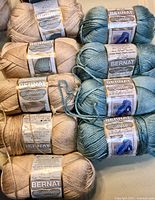 Group of all beige and teal Bernat Satin yarn skeins