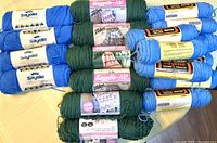 Stack of blue, green and light blue yarn skeins with labels visible