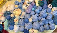 Wide view of assorted yarn balls in blue, white, teal, green and pink tones