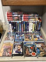 Wide shot of full lot on countertop showing stacked and upright VHS tapes.