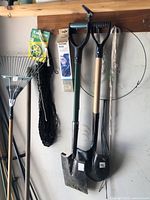 Wall-mounted shelf with two spade shovels, coil of twine, garden netting, soil moisture meter