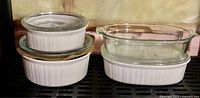 Four CorningWare casseroles on shelf