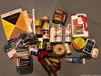Entire lot overview showing sanding supplies, stains, spray paint, insect killer, screwdrivers and other items