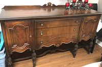 Full view of wood sideboard showing doors, drawers, legs, and finish