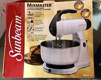 Retail box showing Sunbeam Mixmaster 12-Speed Stand Mixer model 2623-33 with image of mixer, bowl and pancakes