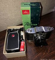 Camera, flash unit, battery and Walz Flash Master box on table