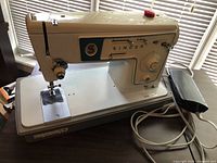 Full view of Singer sewing machine with foot pedal on table