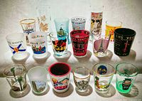 All 18 shot and shooter glasses arranged in two rows