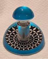 Full view of perfume bottle showing turquoise dome top and geometric base