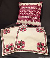 Cushion cover propped upright with two matching table toppers displayed in front