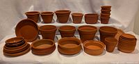Wide shot of entire collection of terracotta pots, planters and trays displayed on three tiers