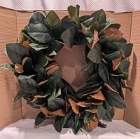 Front view of artificial magnolia leaf wreath attached to cardboard backing