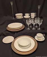 Full lot showing dinnerware, chargers, wine glasses, candlesticks