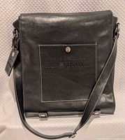 Front view of black shoulder bag with adjustable strap and TIFF 2005 embossing