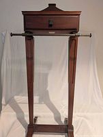 Full front view of valet stand displaying drawer, metal rod and legs