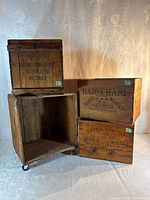 Group shot of the four wooden crates showing printed lettering and crate on wheels